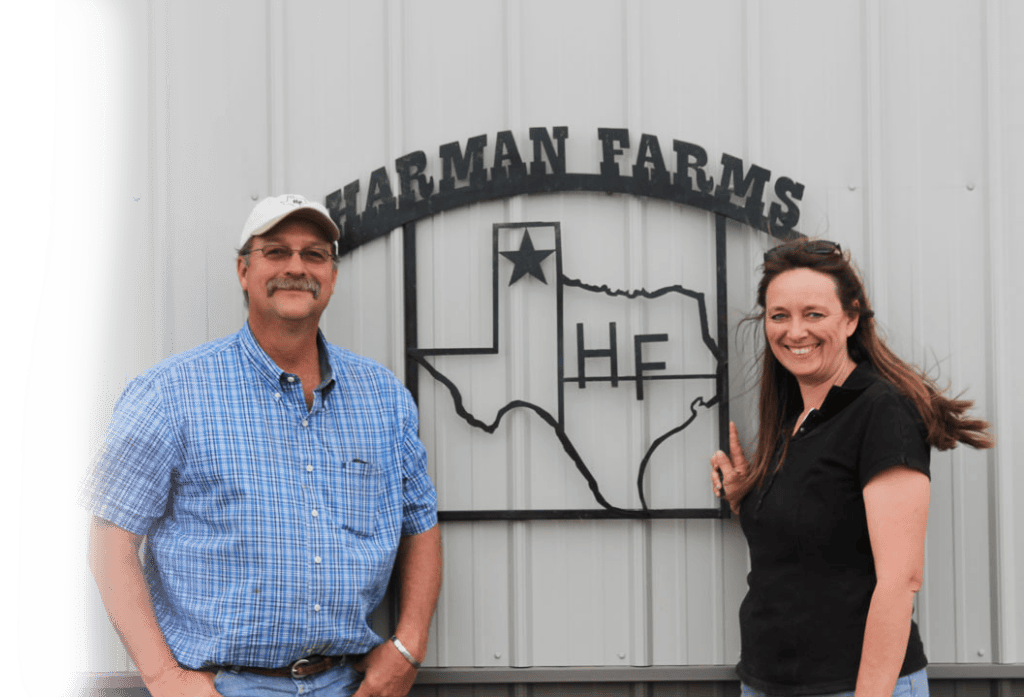 Wayne and Leslie Harman standing in front of a Harman Farms sign